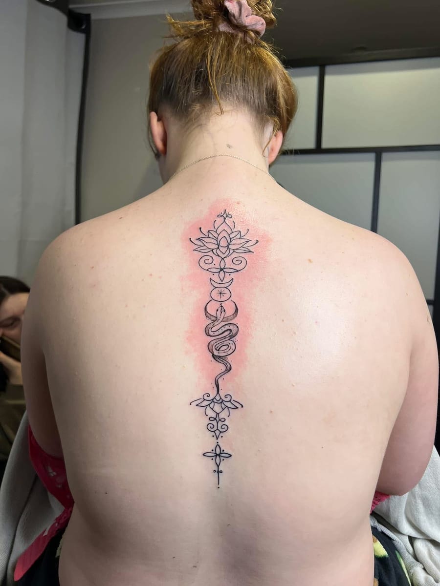 Lotus and serpent spine tattoo
