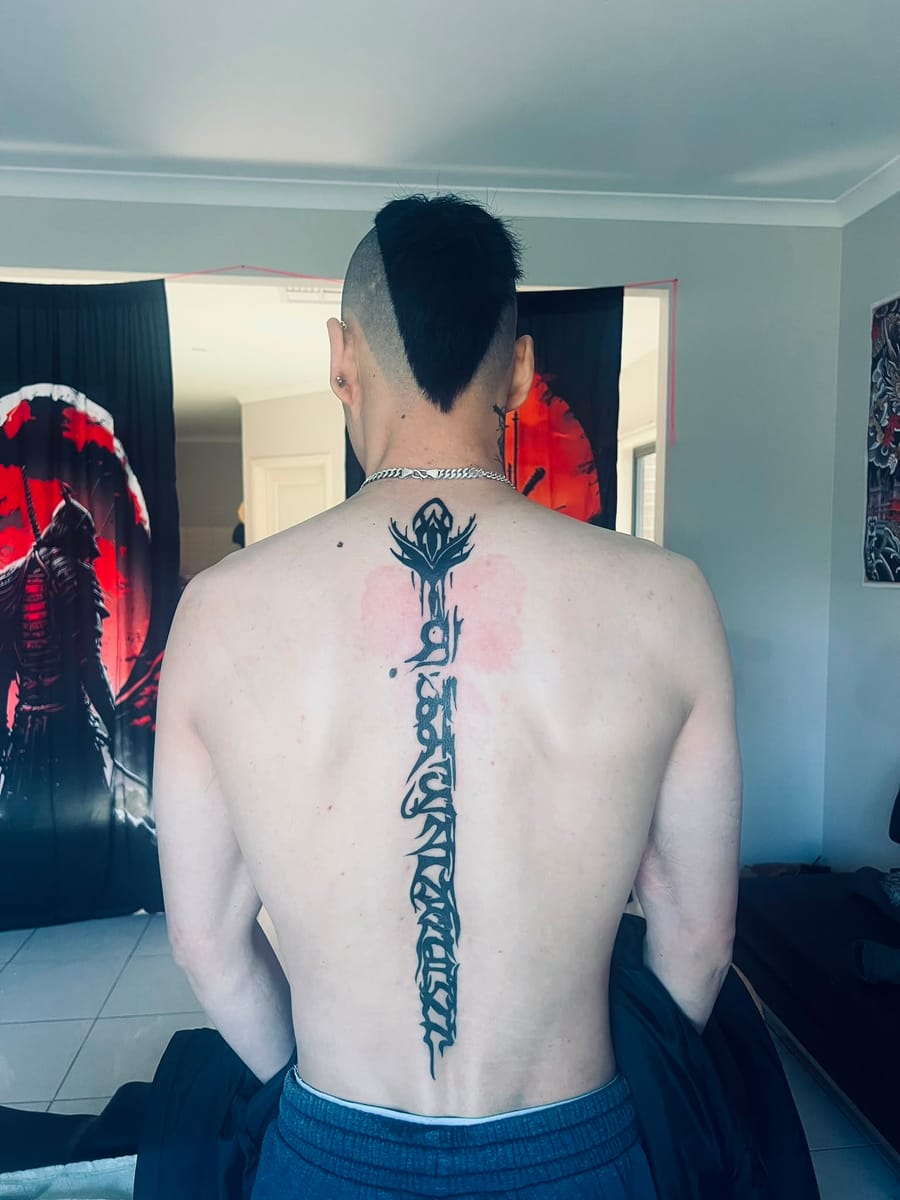 Calligraphy spine tattoo