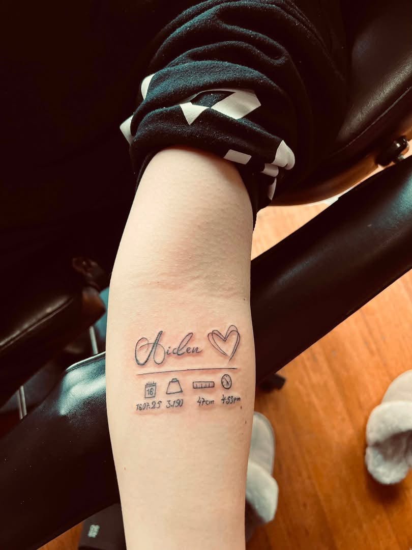 Fine-line birth details tattoo